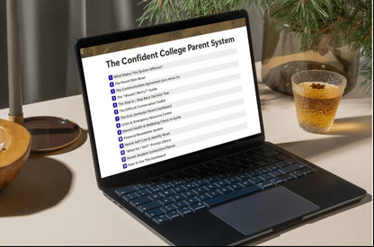 A black laptop sits open on a tabletop, displaying a document titled "The Confident College Parent System." The scene is styled with a wooden bowl of popcorn on the left, a glass of amber drink on the right, and evergreen branches in the background, suggesting a home or cafe environment.